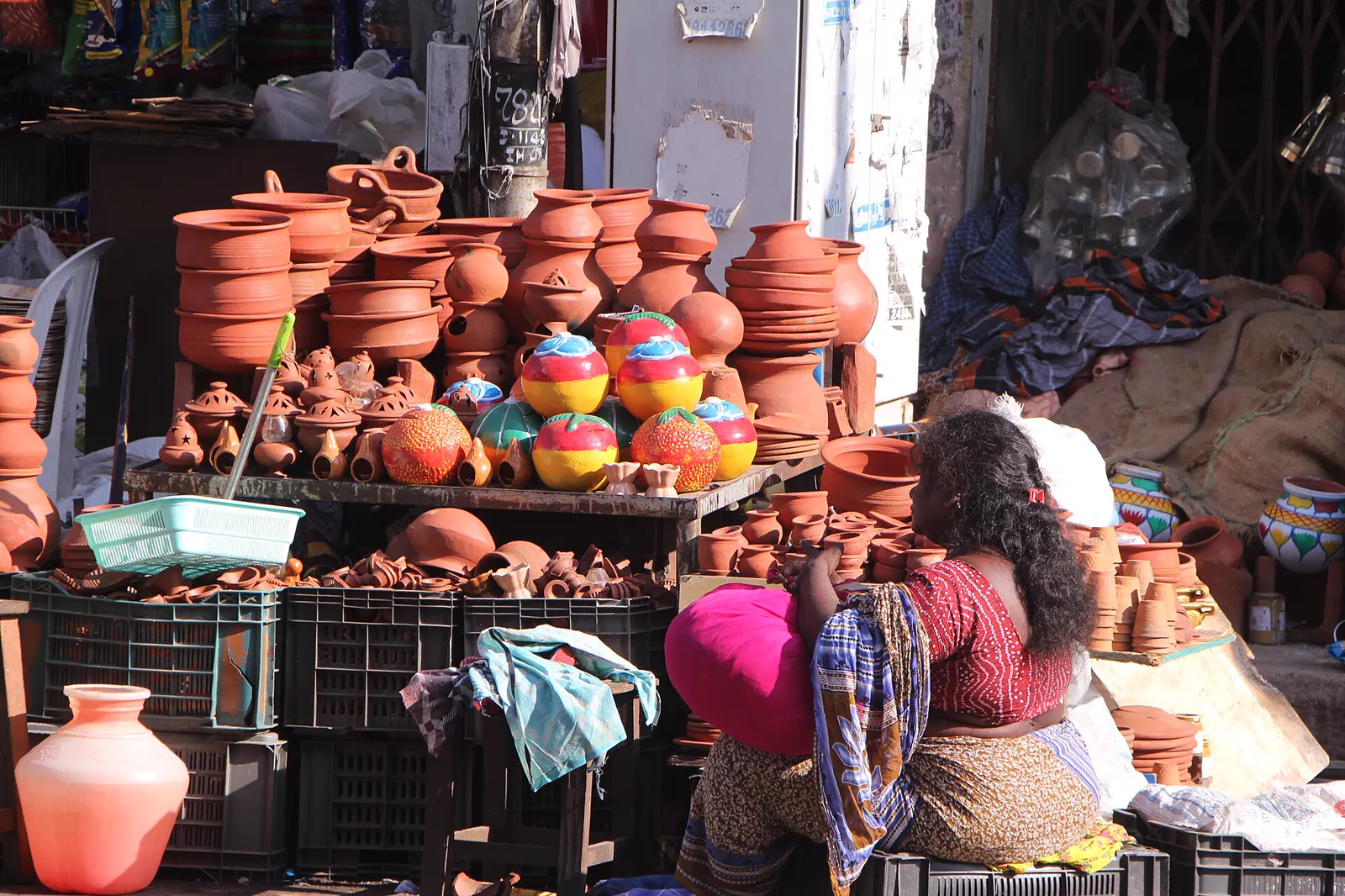 A street vendor's stall stacked with clay pots and diyas